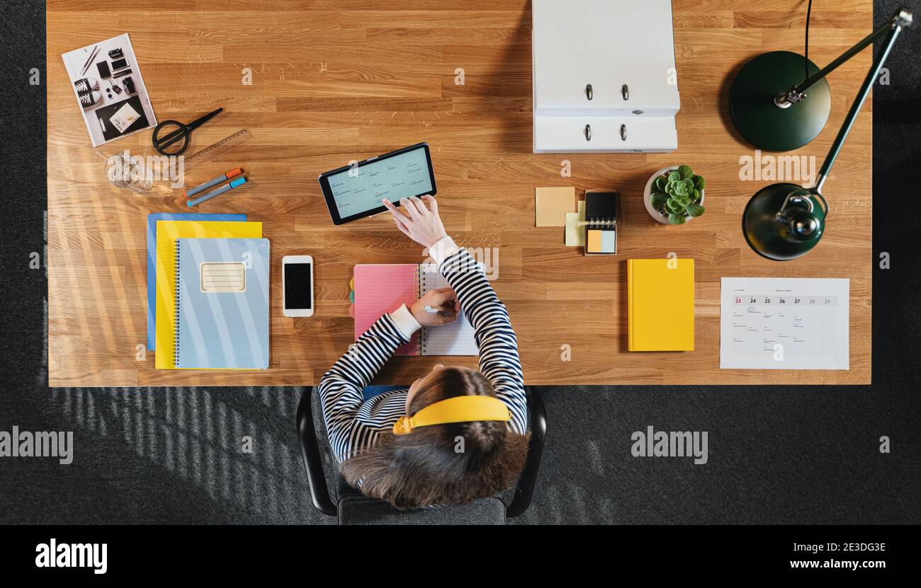 Vue de dessus d'une étudiante travaillant sur un ordinateur au bureau à la maison. Banque D'Images