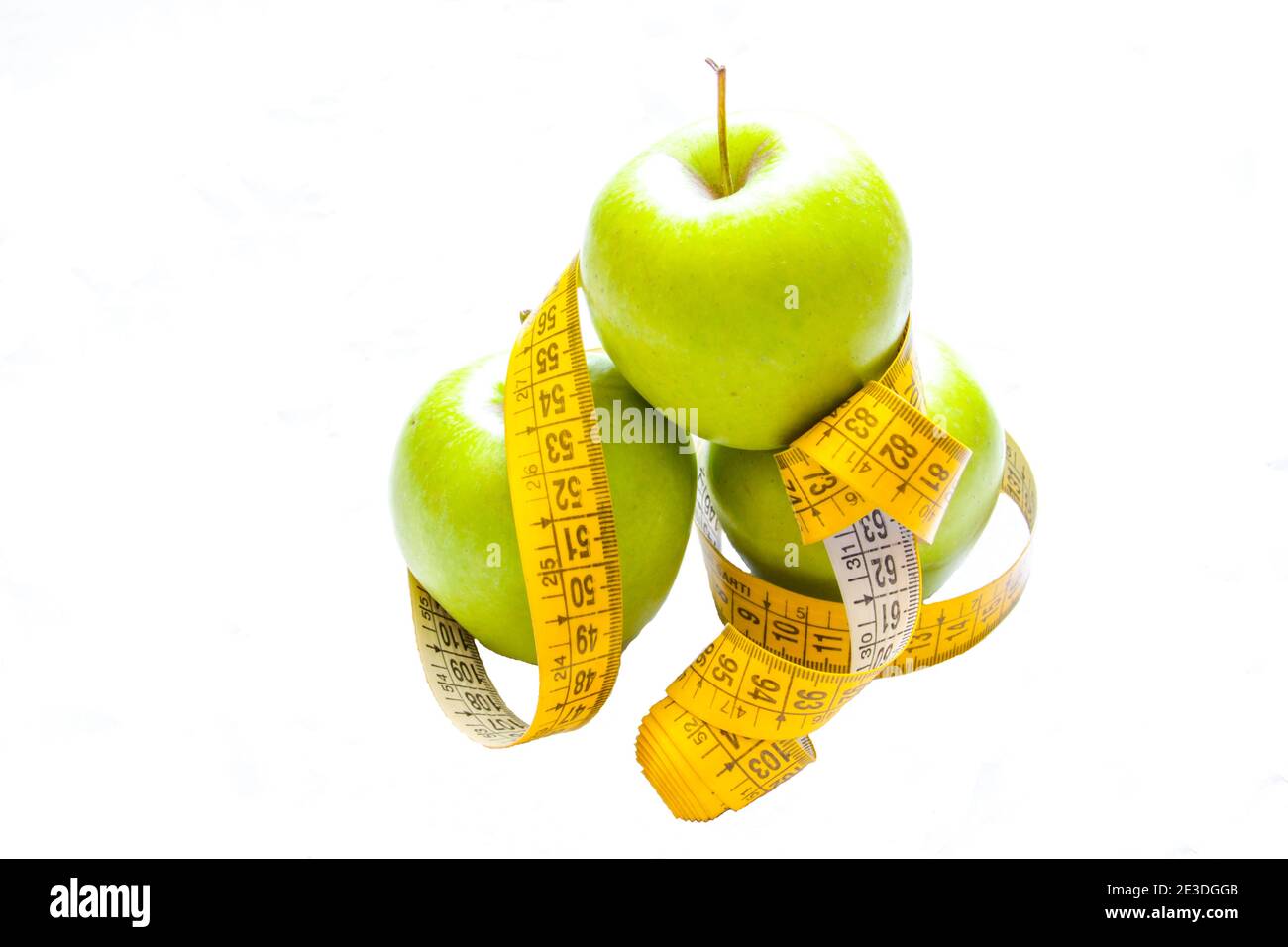 Régime alcalin. Pommes vertes gros plan avec mètre-ruban isolé sur fond blanc. Alimentation mince et manger pour la santé. Banque D'Images