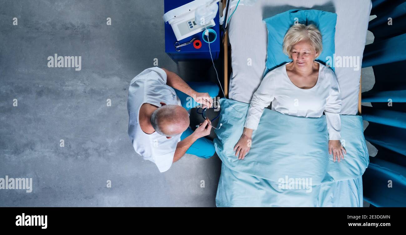 Vue de dessus du médecin avec stéthoscope examinant le patient au lit à l'hôpital. Copier l'espace. Banque D'Images