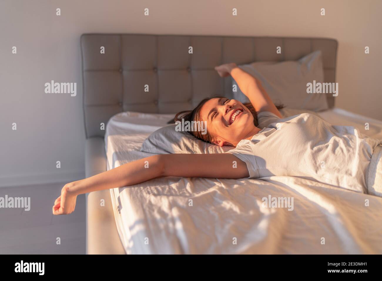 Une femme heureuse couchée dans un confortable matelas en latex mousse dans  un hôtel de luxe en profitant de la détente week-end escapade saut dans le  lit. Femme asiatique avec ouvert Photo