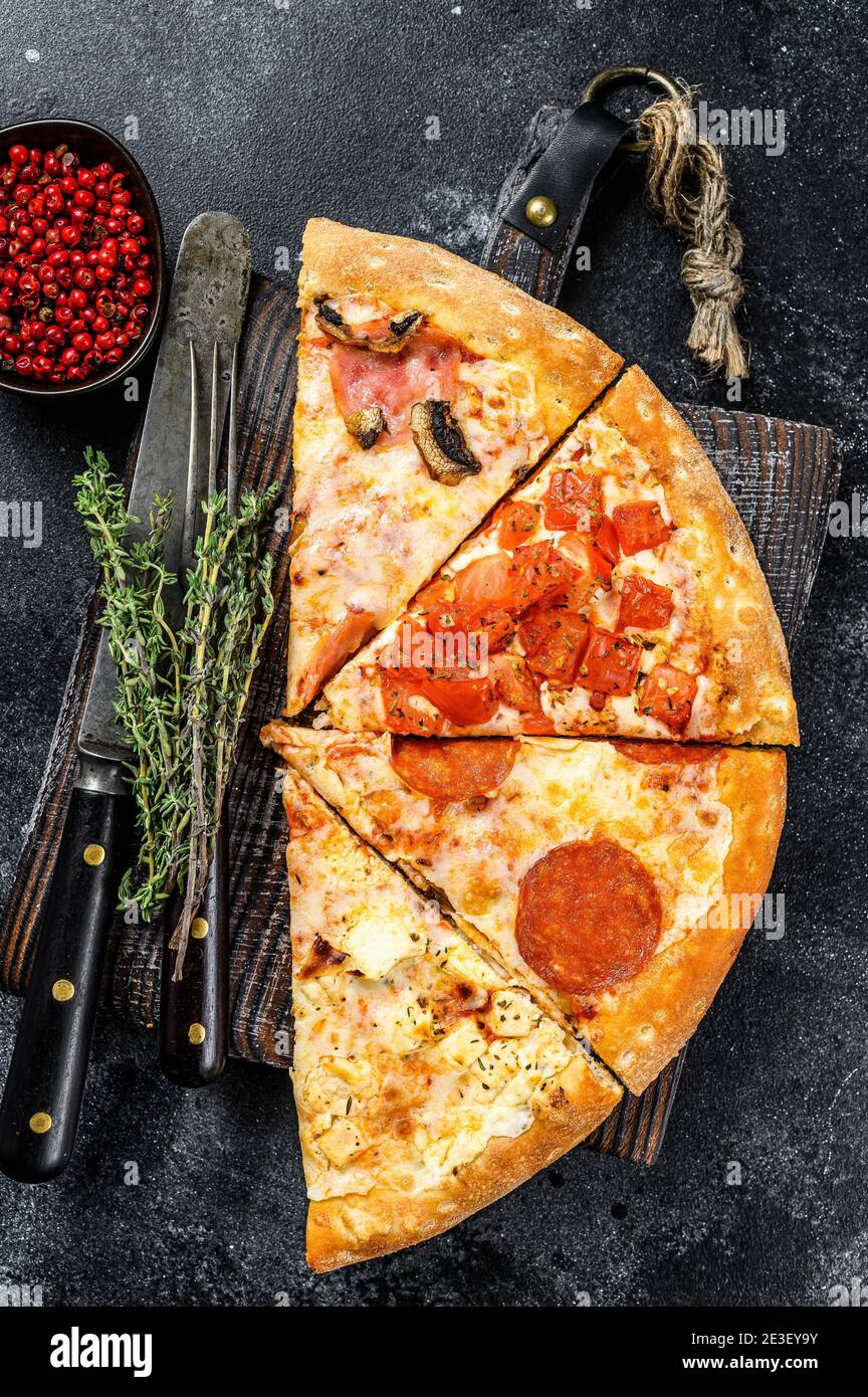 Ensemble de différentes tranches de pizza. Arrière-plan noir. Vue de dessus Banque D'Images