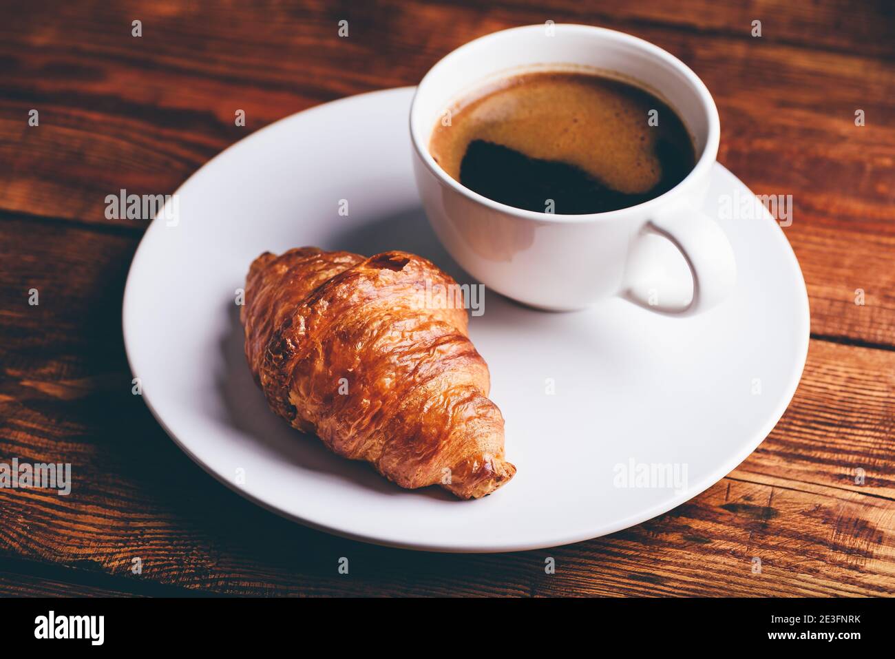 Tasse de café noir et de croissant frais sur White plate Banque D'Images