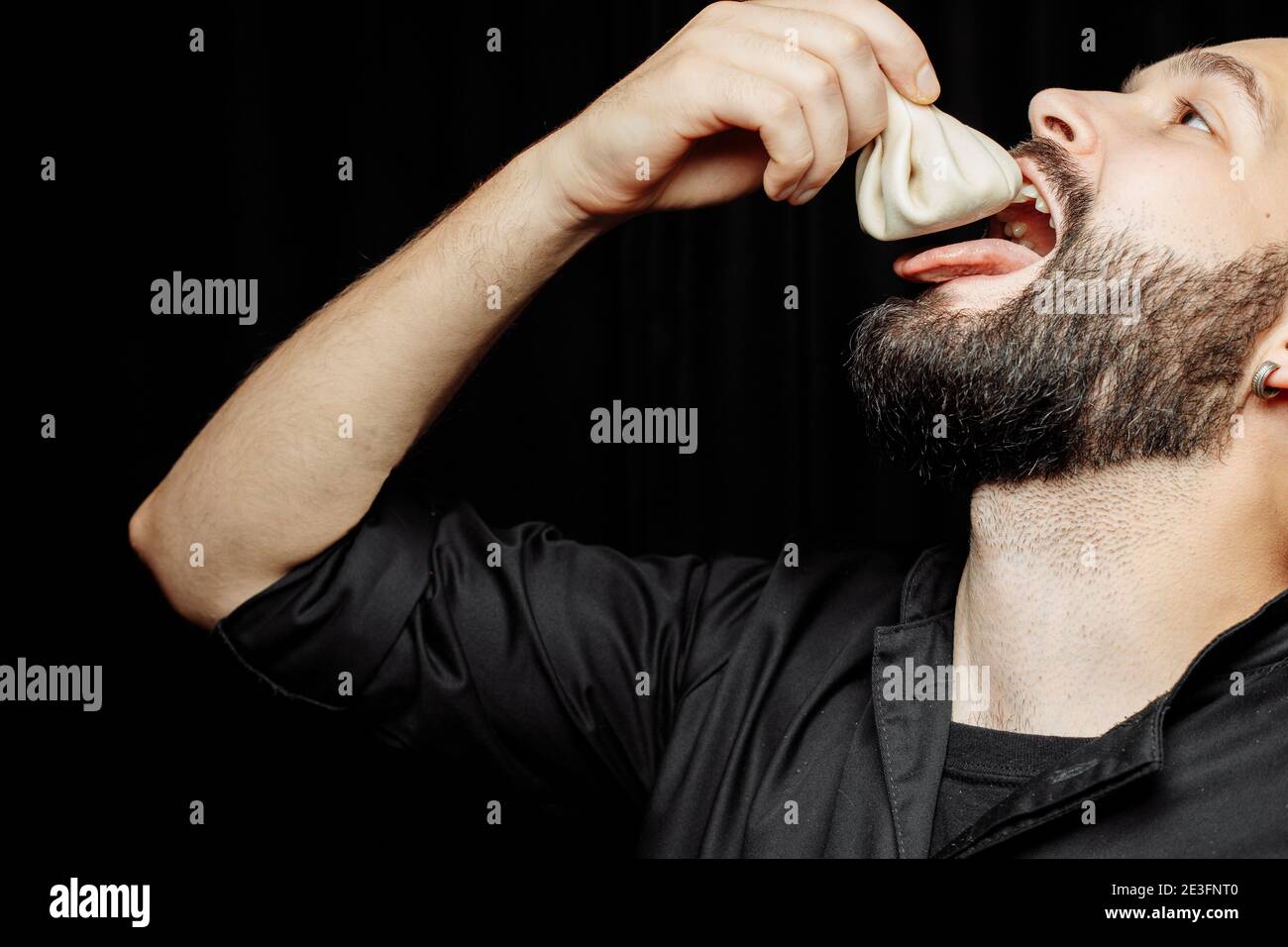 L'homme barbu mange avec émotion des khinkali. Le plat national géorgien khinkali. Concept de publicité photo de khinkali Banque D'Images