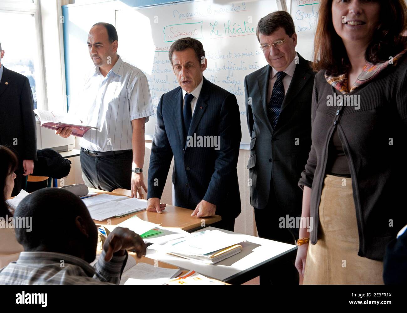 Le président français Nicolas Sarkozy et le ministre de l'éducation Xavier  Darcos parlent aux élèves lorsqu'ils visitent le lycée Jean-Baptiste Clément  à Gagny, dans la banlieue parisienne, le 18 mars 2009. Nicolas