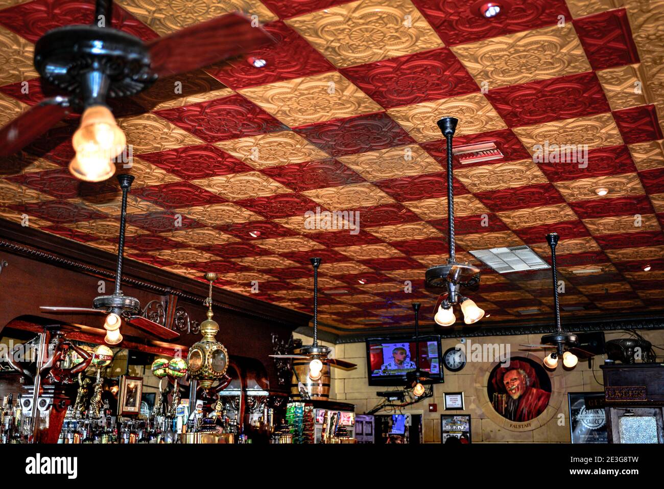 Un plafond rouge et jaune décoratif en étain pressé dans le plus ancien bar de Floride, le Palace Saloon à la plage de Fernandian sur l'île Amelia, FL Banque D'Images