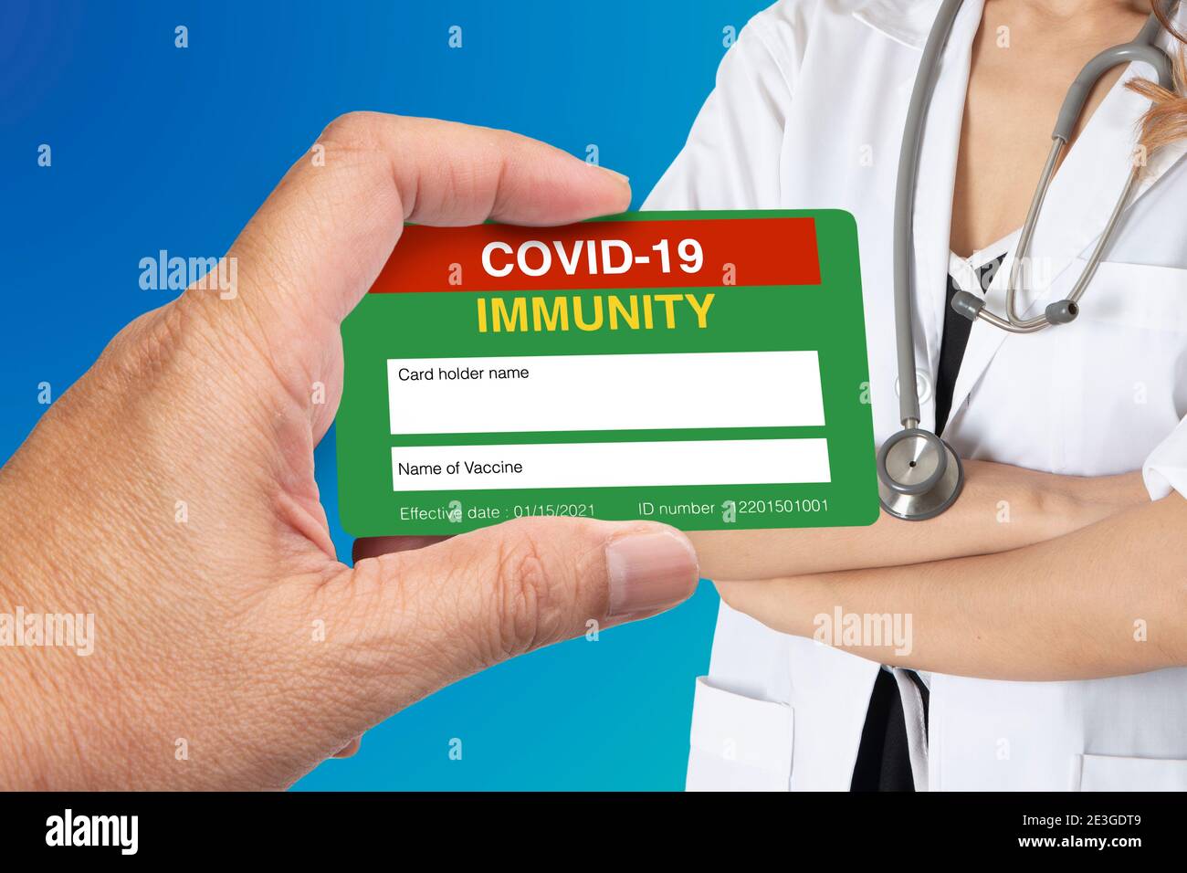 Main tenant la carte de certification immunitaire Covid-19 avec une femme médecin sur fond bleu. Banque D'Images Main tenant la carte de certification immunitaire Covid-19 avec une femme médecin sur fond bleu. Banque D'Images