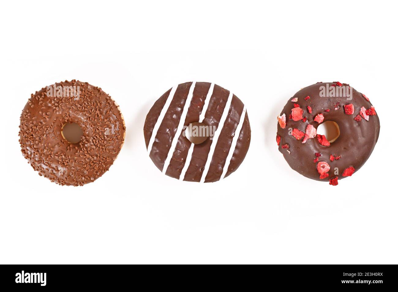 Trois biscuits glacés au chocolat avec différentes topics d'affilée sur fond blanc Banque D'Images