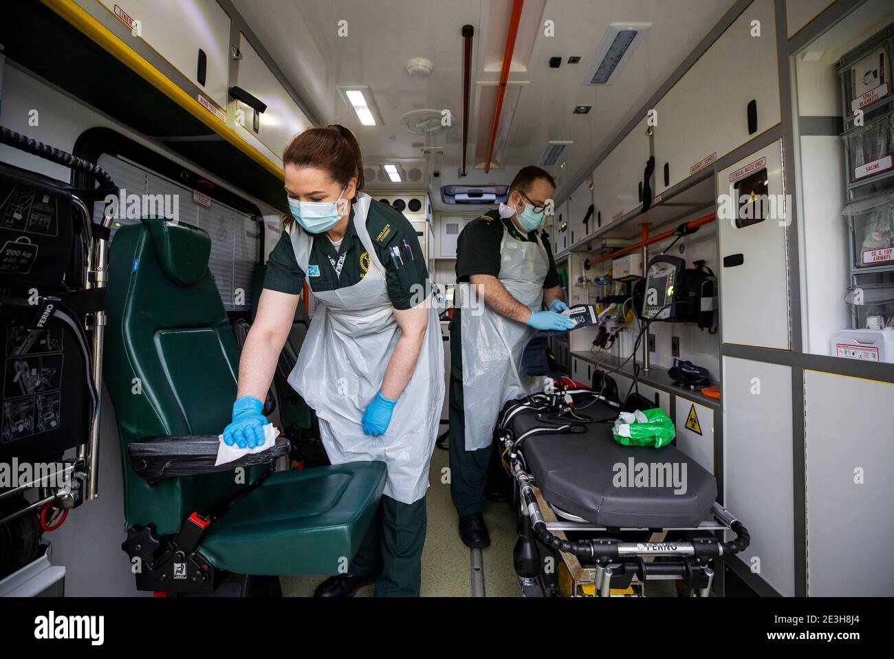 L'étudiante EMT Ruth Corscaden (à gauche) et le paramédic Daniel McCollam nettoient l'ambulance après avoir apporté un patient à l'hôpital Causeway pendant leur quart de travail pour le service d'ambulance d'Irlande du Nord couvrant les hôpitaux du Northern Trust. Date de la photo: Lundi 18 janvier 2021. Banque D'Images