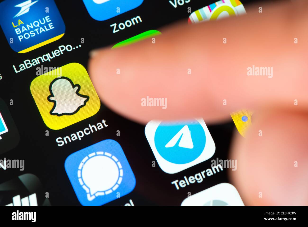 Un doigt pointant vers l'icône de l'application Snapchat sur l'écran de l'iPhone d'Apple. Snapchat est une application de messagerie multimédia développée par Snap Inc Banque D'Images
