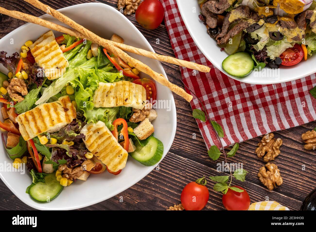 salade de halloumi et salade de bœuf dans deux assiettes séparées sur fond de bois. Banque D'Images