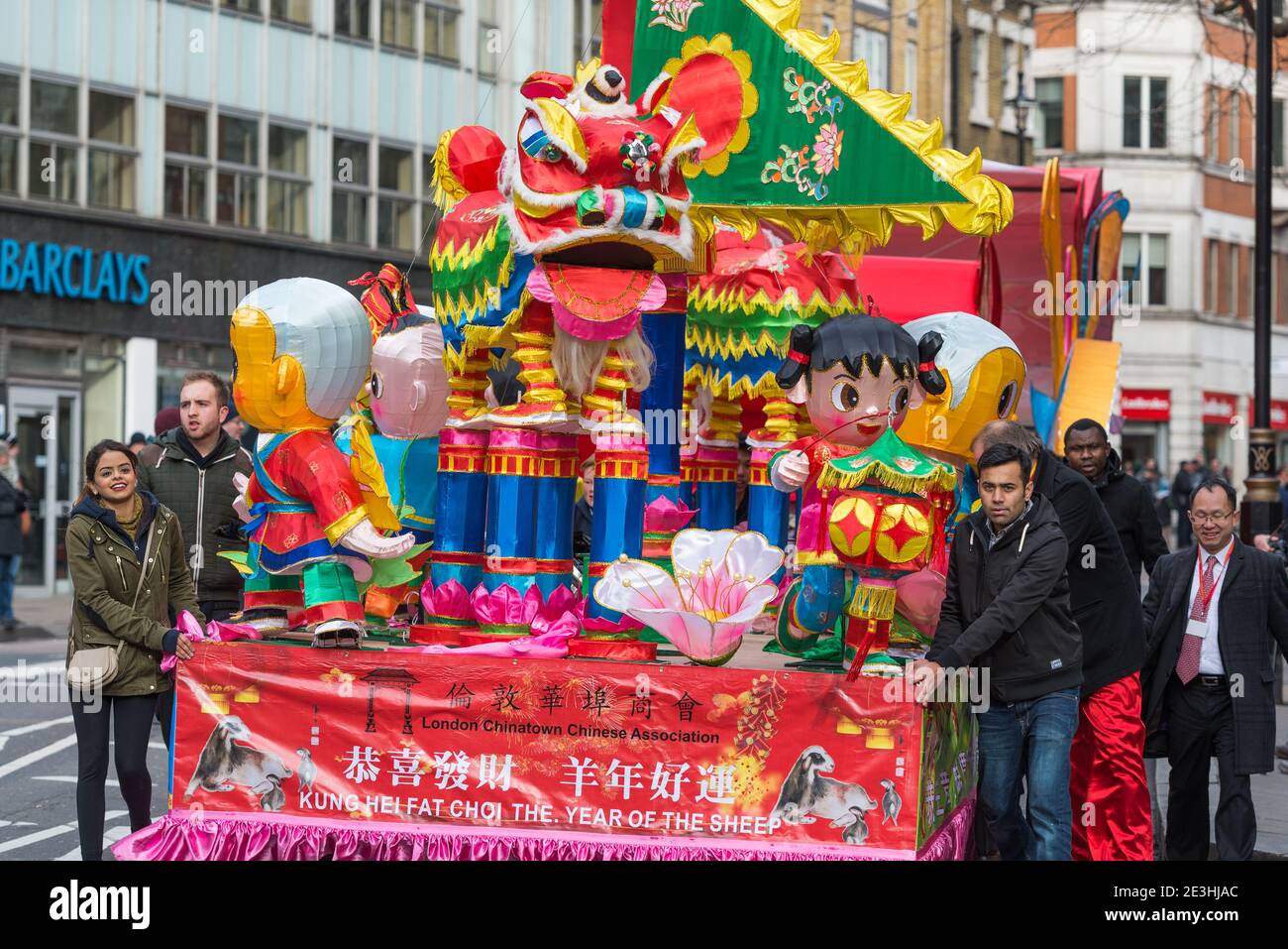 Les gens qui poussent un char de carnaval dans le cadre du défilé de rue de célébration du nouvel an de Sheep. Londres février 2015. Banque D'Images