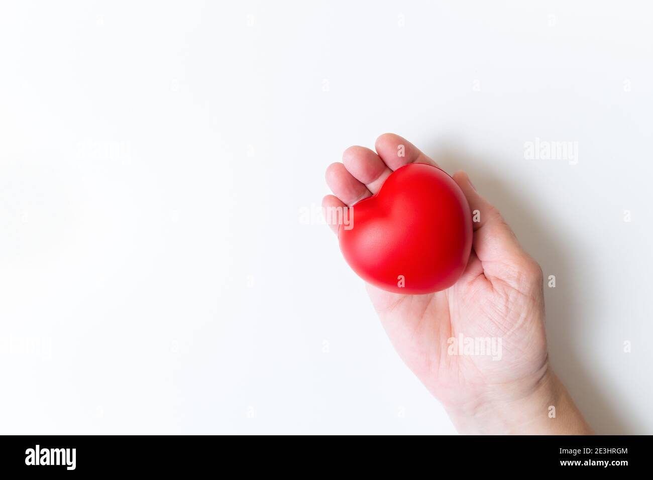 Vue de dessus du cœur rouge à portée de main. Main tenant le cœur rouge sur fond blanc avec espace de copie. Journée nationale des donneurs d'organes. Journée mondiale du cœur. Journée mondiale de la santé Banque D'Images
