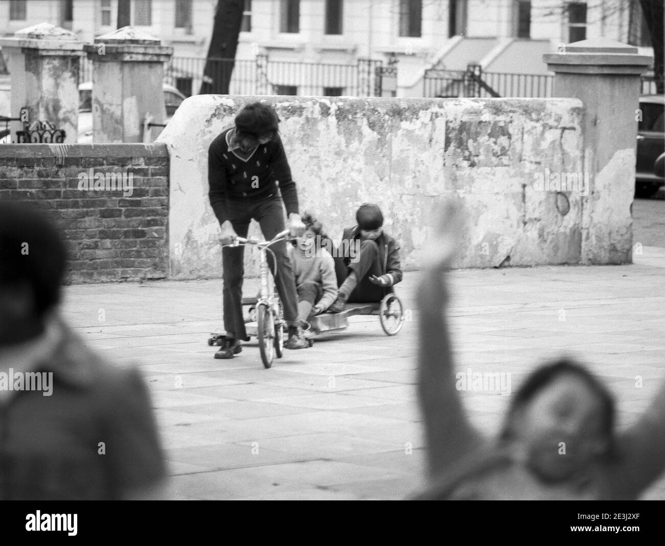 Royaume-Uni, West London, Notting Hill, 1973. Les grandes maisons de quatre étages en ruine et en ruine commencent à être restaurées et redécorées. Enfants jouant autour de la place Powis. Banque D'Images