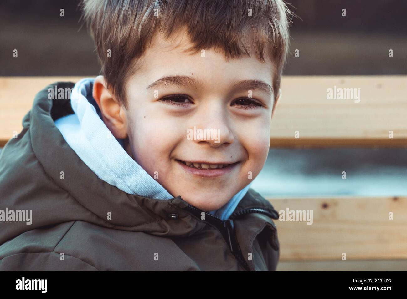 Portrait d'un mignon petit garçon souriant timidement Banque D'Images