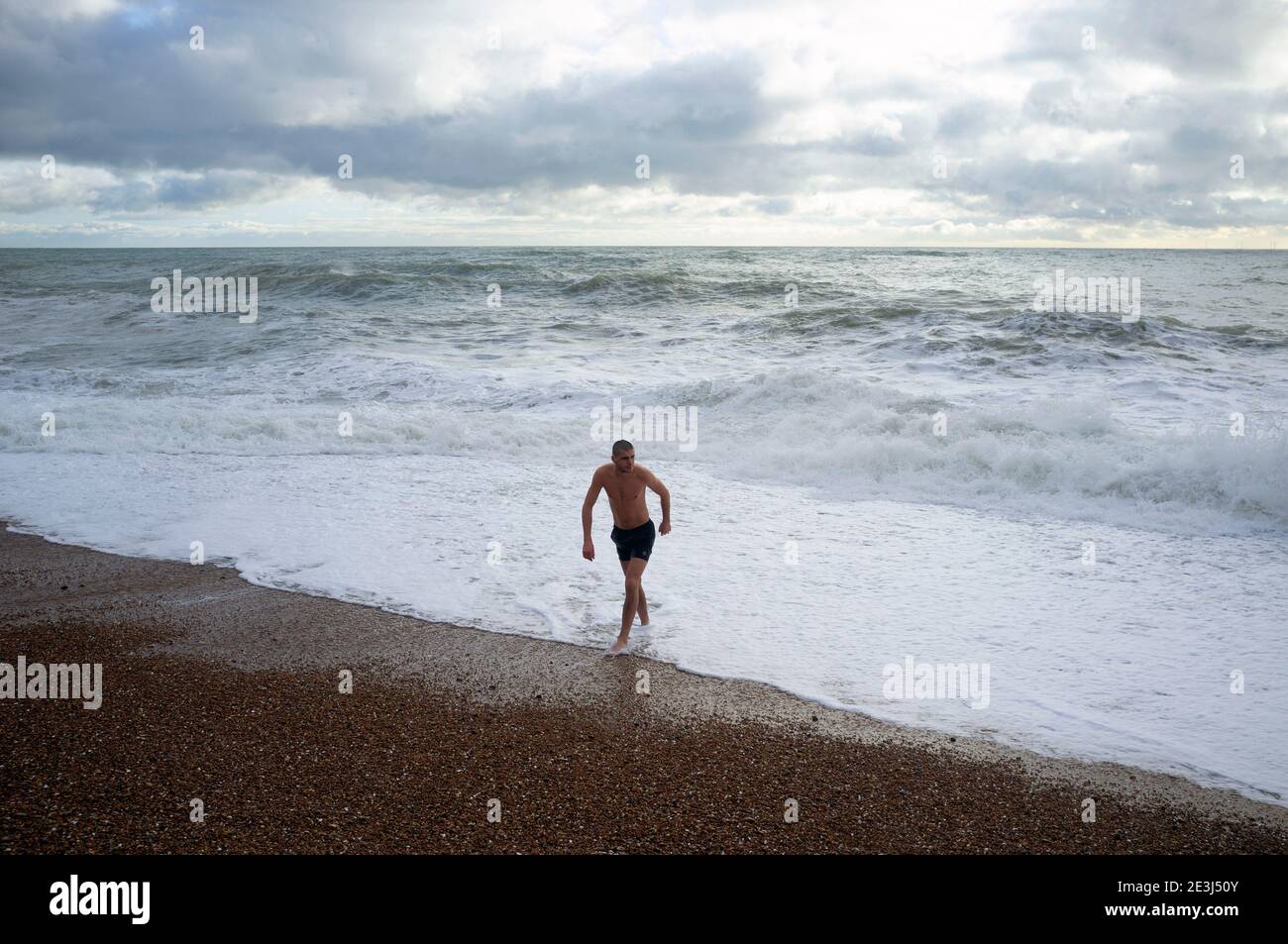 Un nageur émerge de la mer d'hiver agitée à Brighton Banque D'Images