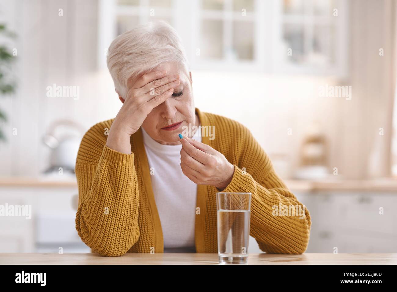 Vieille femme souffrant de maux de tête, prenant la pilule Banque D'Images