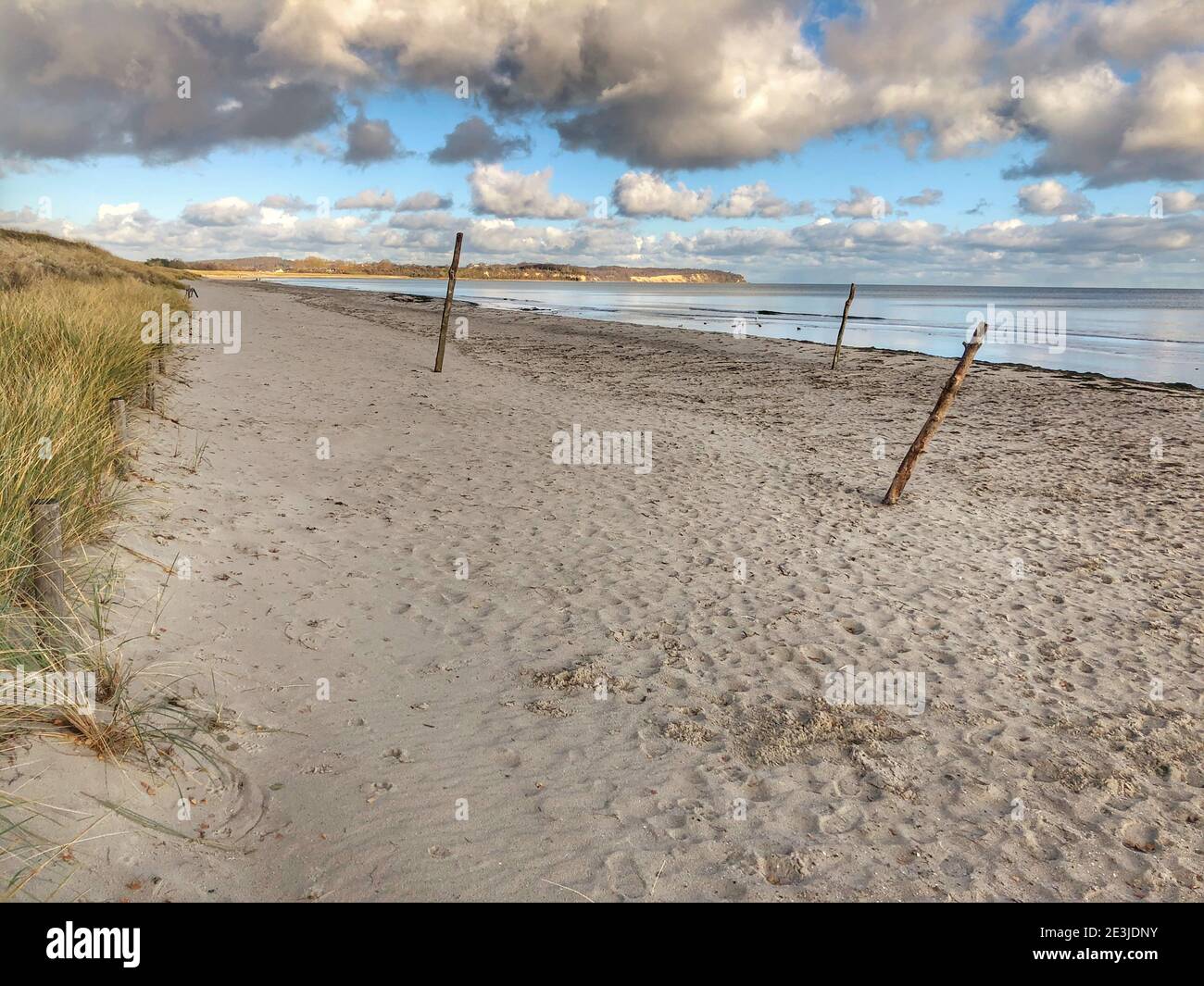 Longue plage de sable avec ciel bleu et quelques nuages Banque D'Images