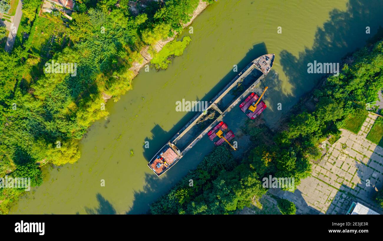 Au-dessus de la vue de dessus sur deux excavatrices drague comme ils dragage, travaillant sur la rivière, canal, l'approfondissement et l'enlèvement des sédiments, la boue du lit de rivière dans un pollué Banque D'Images