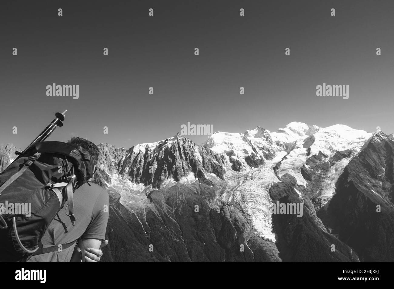 Jeune randonneur (irréalisable; vue arrière) admirant la neige couverte de montagne du Mont blanc et de l'aiguille du midi dans les Alpes. Trekking d'été en montagne Banque D'Images