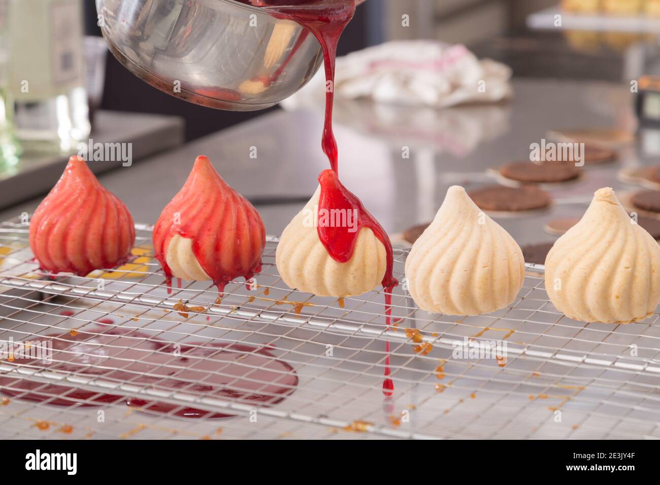 Le processus de fabrication du gâteau de mousse en forme de dôme. Verser la cerise sur le gâteau. Gros plan. Banque D'Images