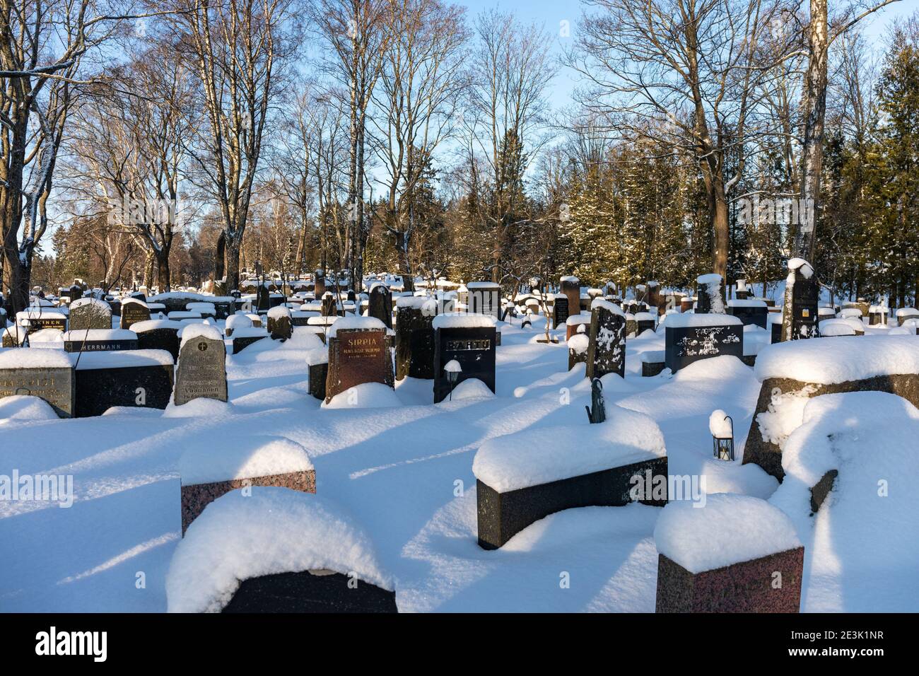 La neige couvrait les pierres de tête et les tombes lors d'une journée d'hiver ensoleillée au cimetière Hietaniemi d'Helsinki, en Finlande Banque D'Images