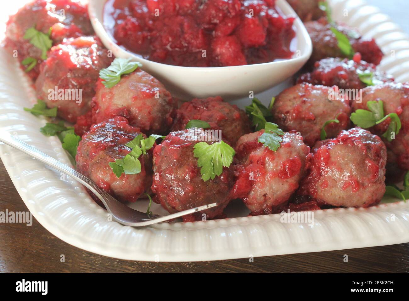 Boulettes de viande chaudes avec sauce aux canneberges sur une assiette blanche Banque D'Images