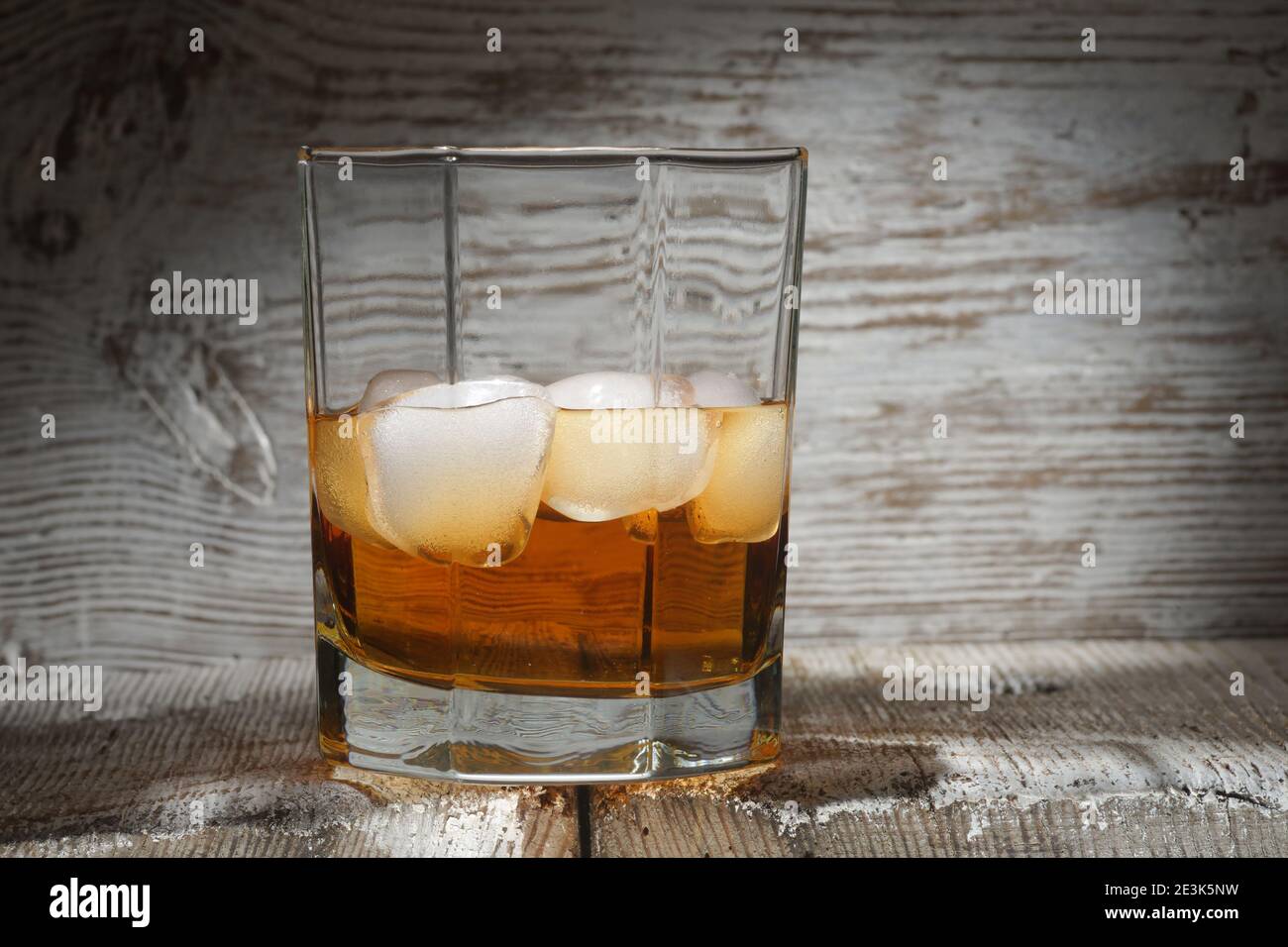 Verre de whisky avec glace blanche sur bois blanc tableau Banque D'Images