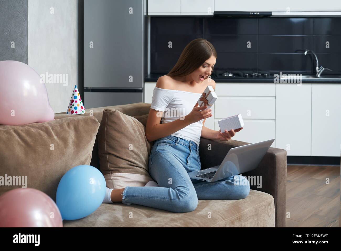 Surprise Jeune Femme Deballage Boite Cadeau Pendant La Fete D Anniversaire Par Appel Video Bonne Dame Utilisant Un Ordinateur Portable Moderne Tout En Restant Seule A La Maison Photo Stock Alamy