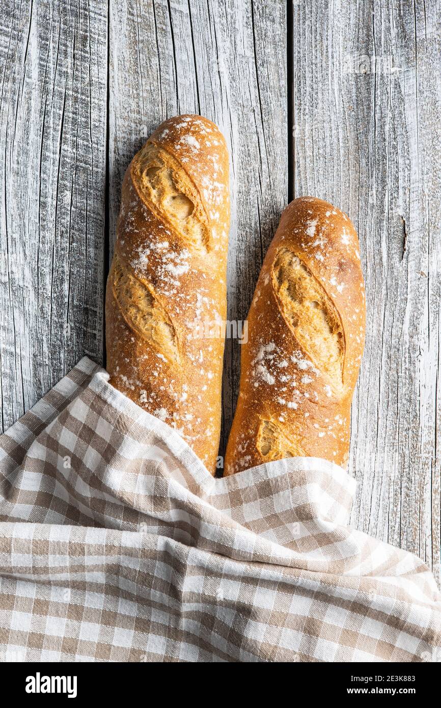 Deux baguettes fraîches croustillantes sur une table en bois. Vue de dessus. Banque D'Images