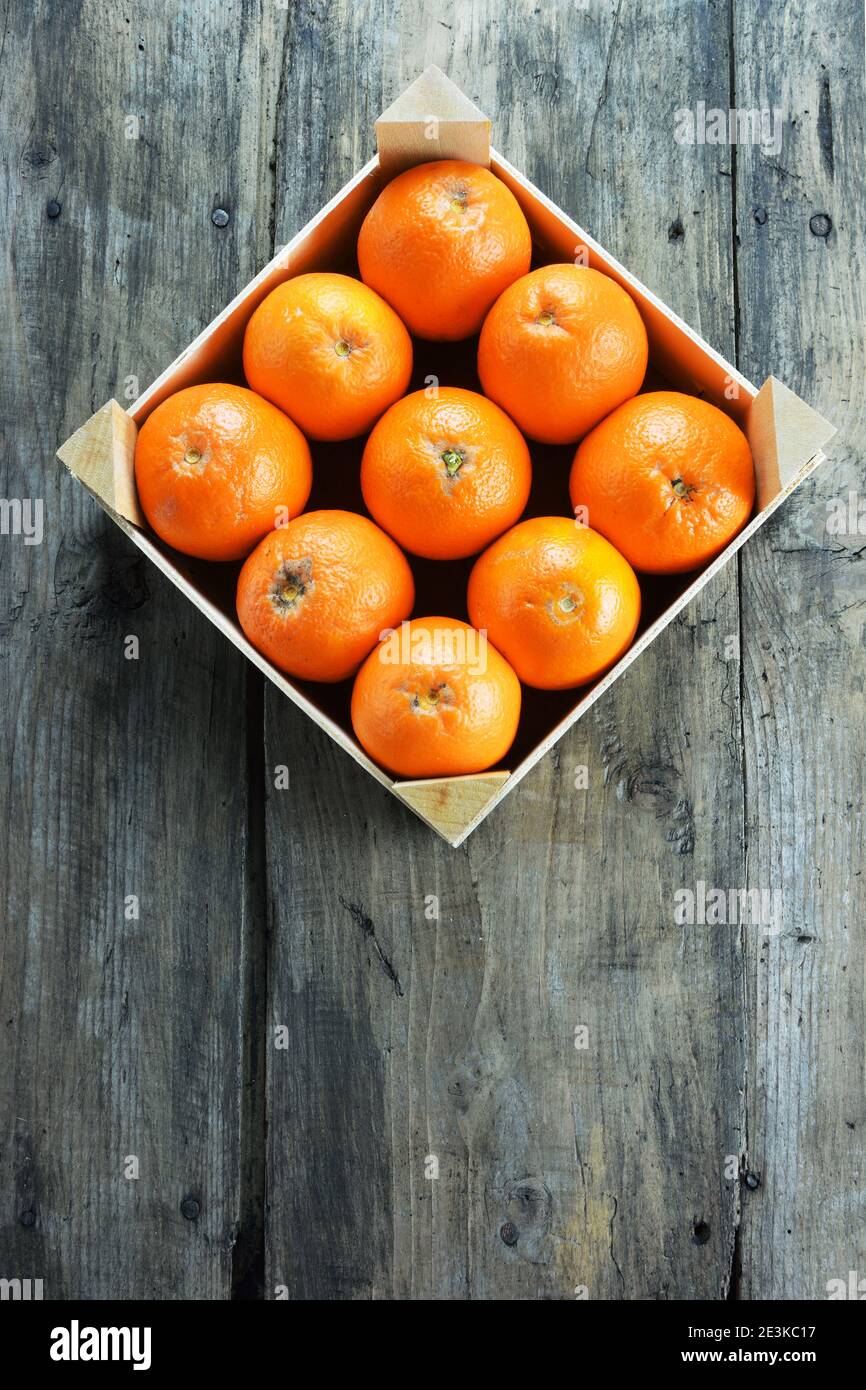 Orange dans une caisse de fruits en bois sur une table rustique en bois Banque D'Images
