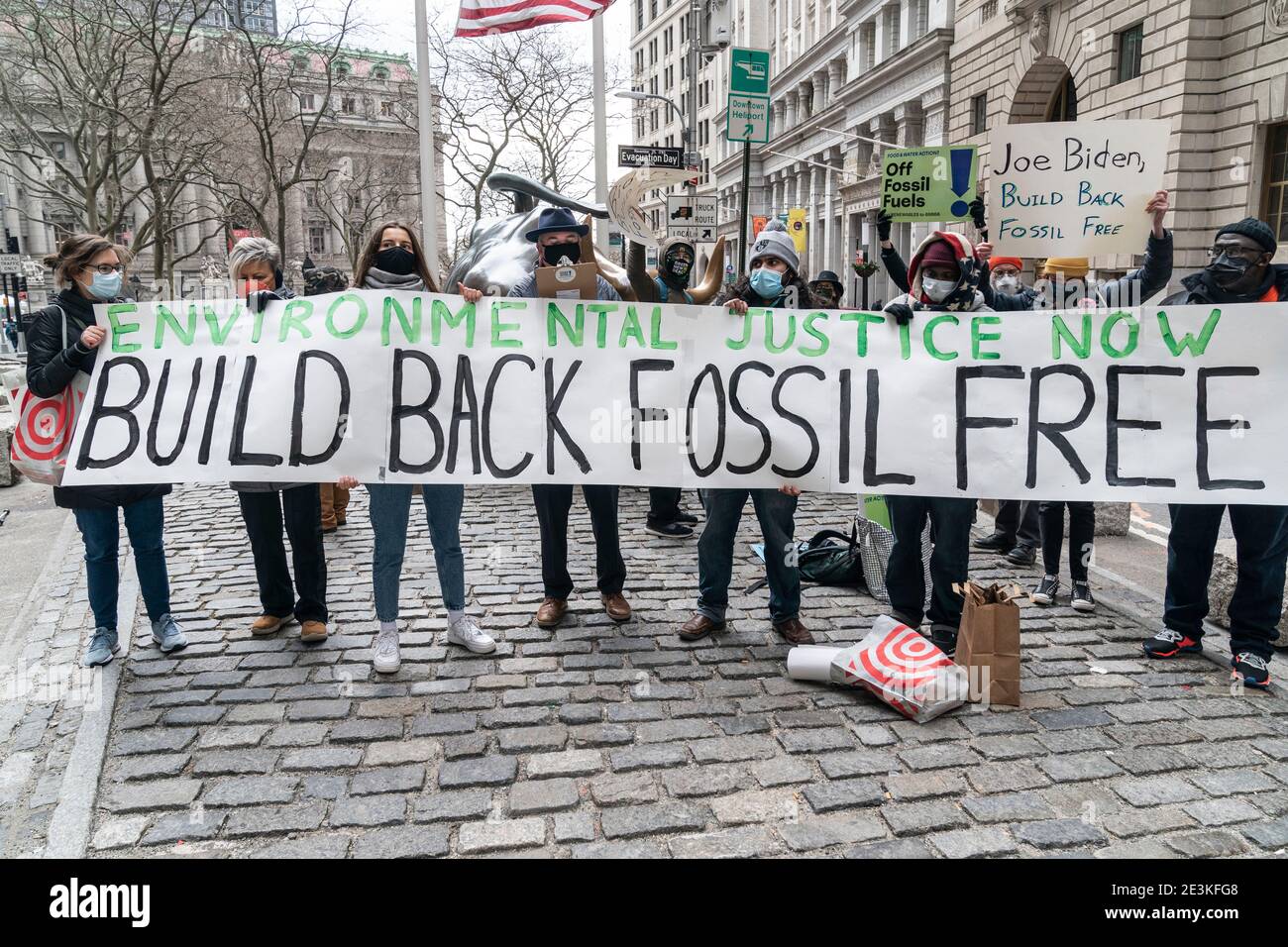 New York, NY - 19 janvier 2021: Les activistes de l'environnement se rassemblent pour exiger construire à nouveau Fossil Free devant la sculpture de Charging Bull sur Broadway Banque D'Images