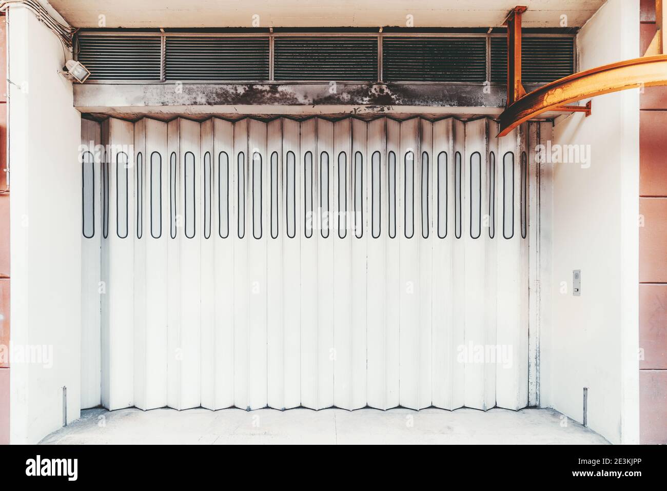 Vue de face d'une porte blanche verticale moderne dans un bâtiment résidentiel ou des portes de l'entrée d'un entrepôt d'un centre commercial, avec un ancien Banque D'Images