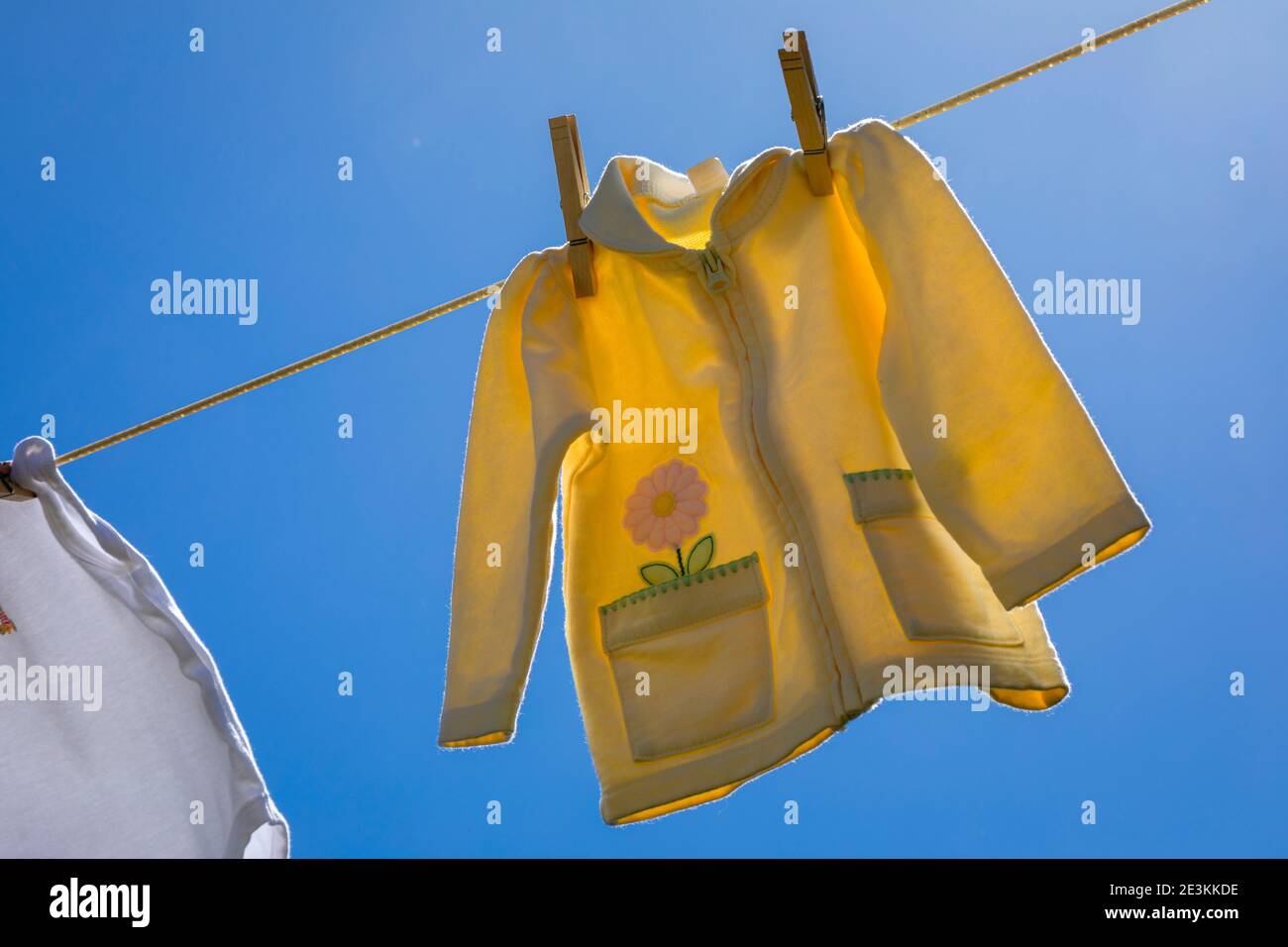 Vêtements de bébé fraîchement lavés suspendus à l'extérieur dans l'air frais. Banque D'Images