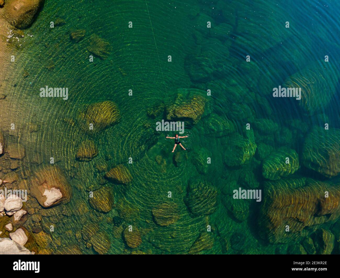 Vue aérienne de l'homme naquant dans l'eau Crystal Clear Banque D'Images