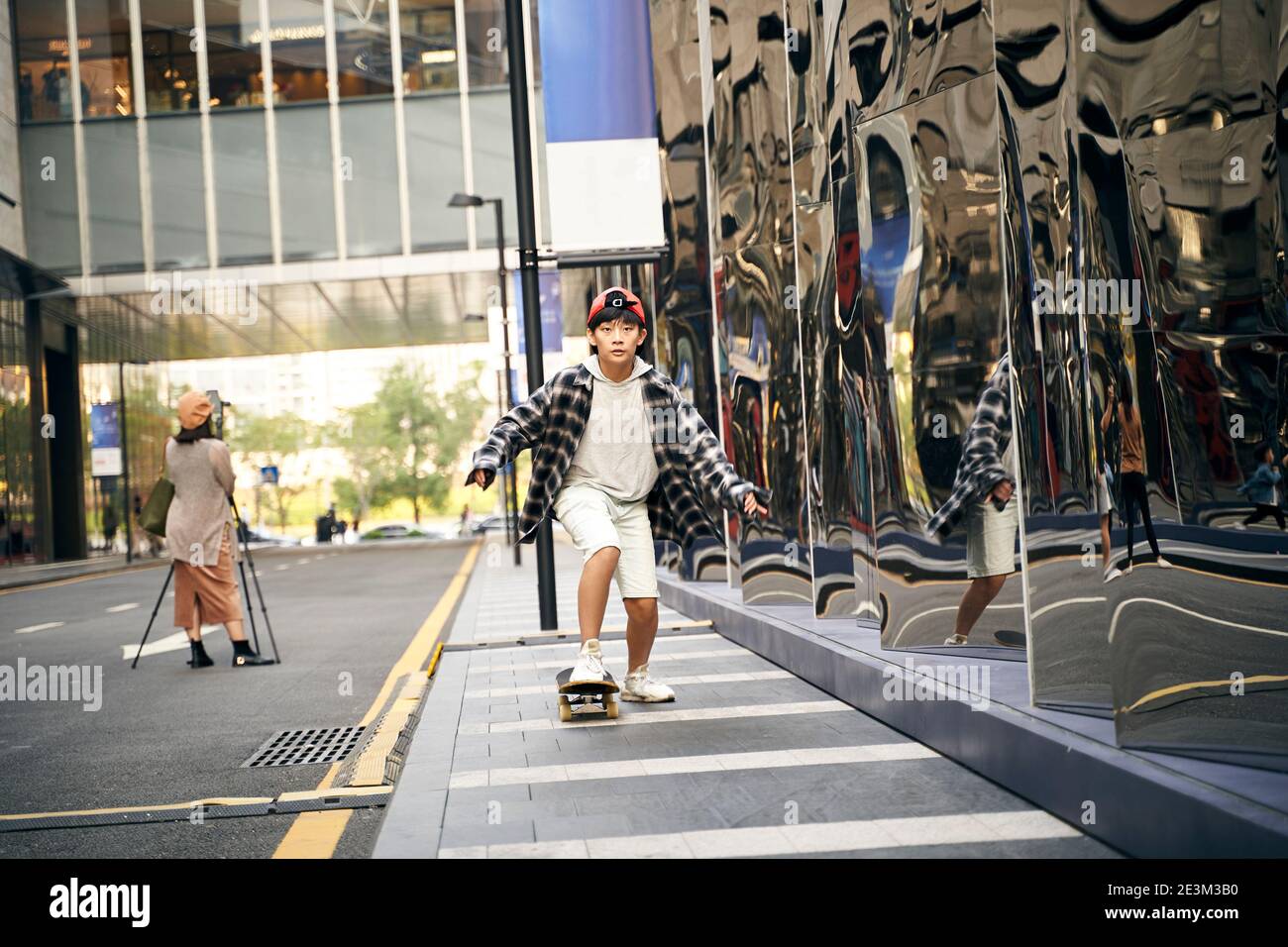 jeunes enfants asiatiques skate à l'extérieur dans la rue Banque D'Images