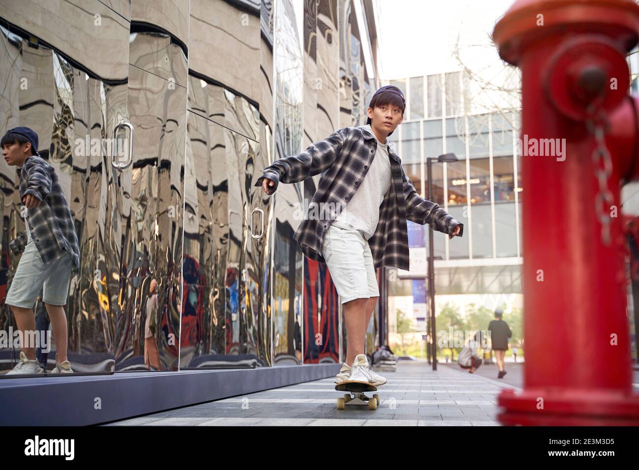 jeunes enfants asiatiques skate à l'extérieur dans la rue Banque D'Images