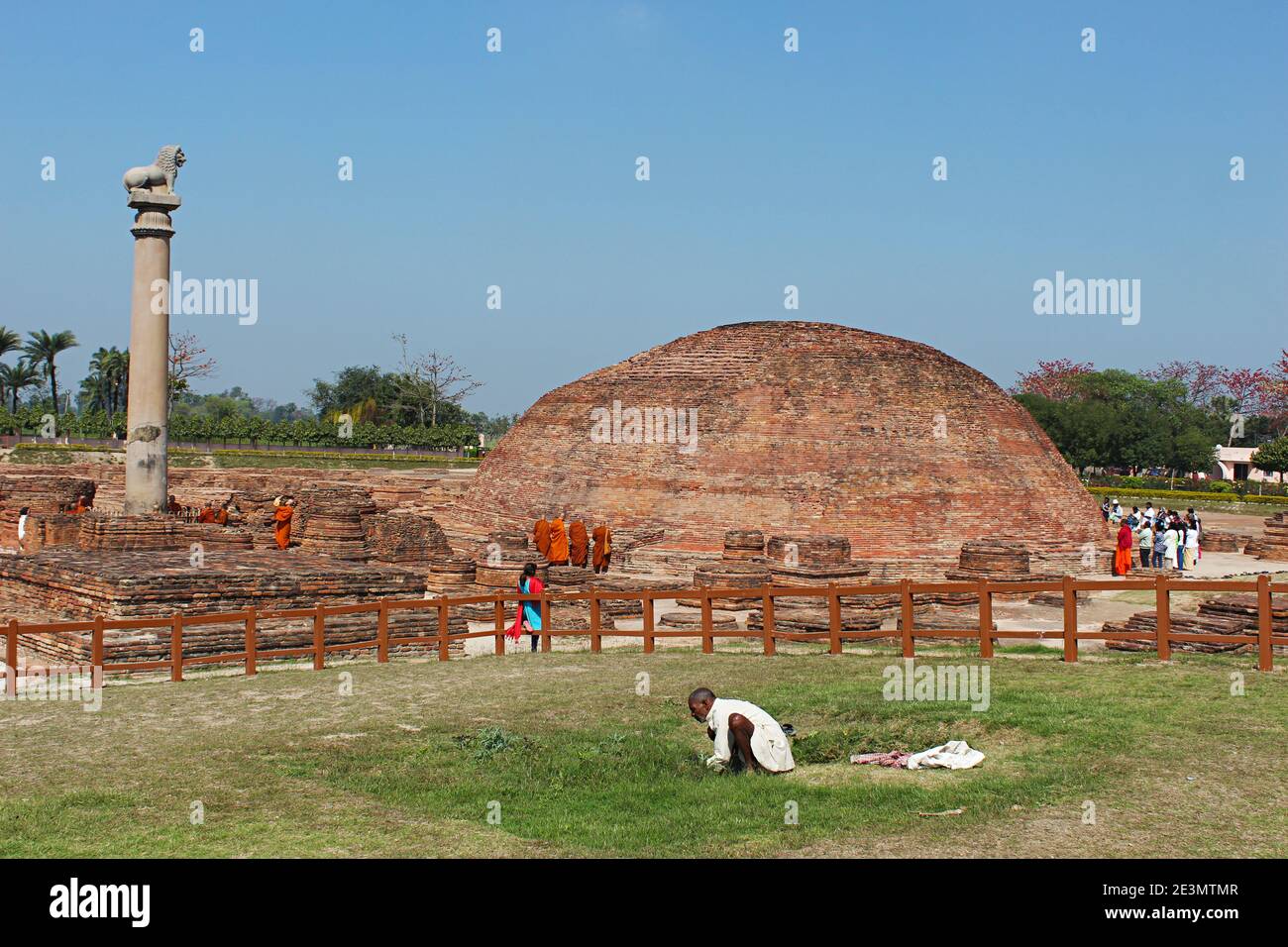 9 mars 2020, Kolhua, Vaishali, Bihar, Inde. Ananda Stupa avec un pilier Asokan. Les dévotés contournent le stupa. Stupa relique qui enca un o Banque D'Images