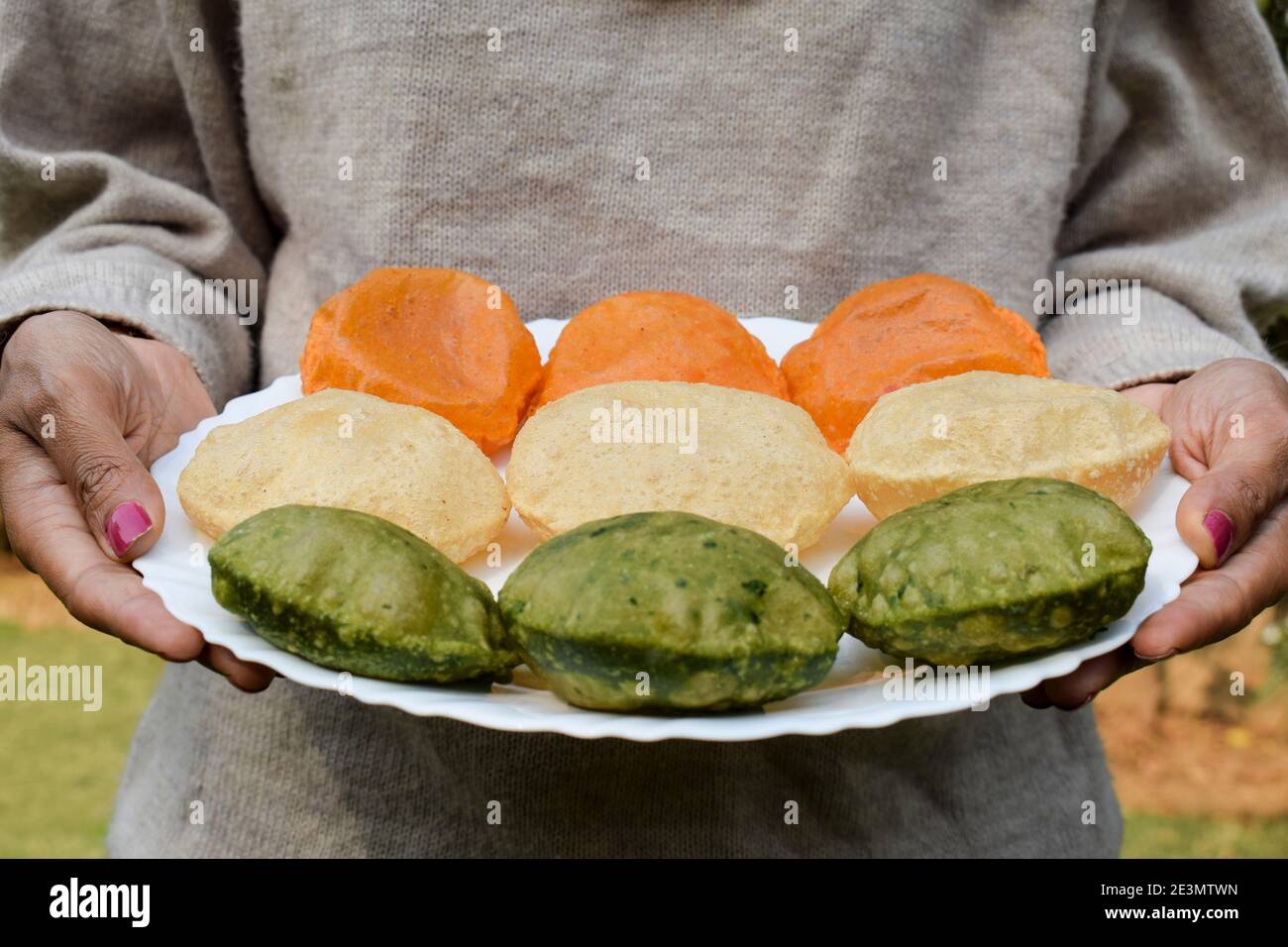 Assiette de conservation pour femme servant des plats à thème tiranga de la journée tricolore de la république indienne servant Puri épinards puri, puri carotte et puri Uni Banque D'Images