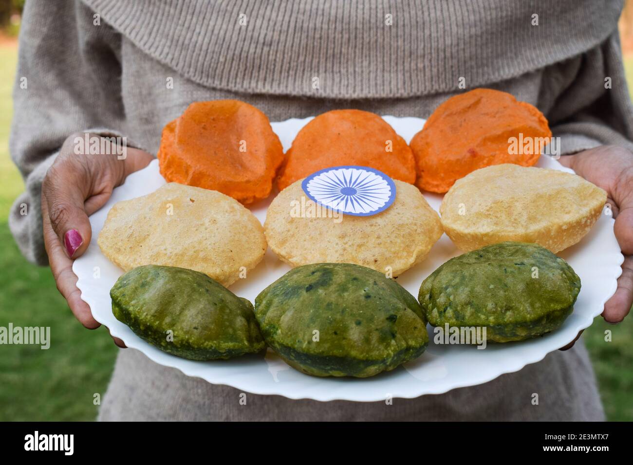 Assiette de conservation pour femme servant des plats à thème tiranga de la journée tricolore de la république indienne servant Puri épinards puri, puri carotte et puri Uni Banque D'Images