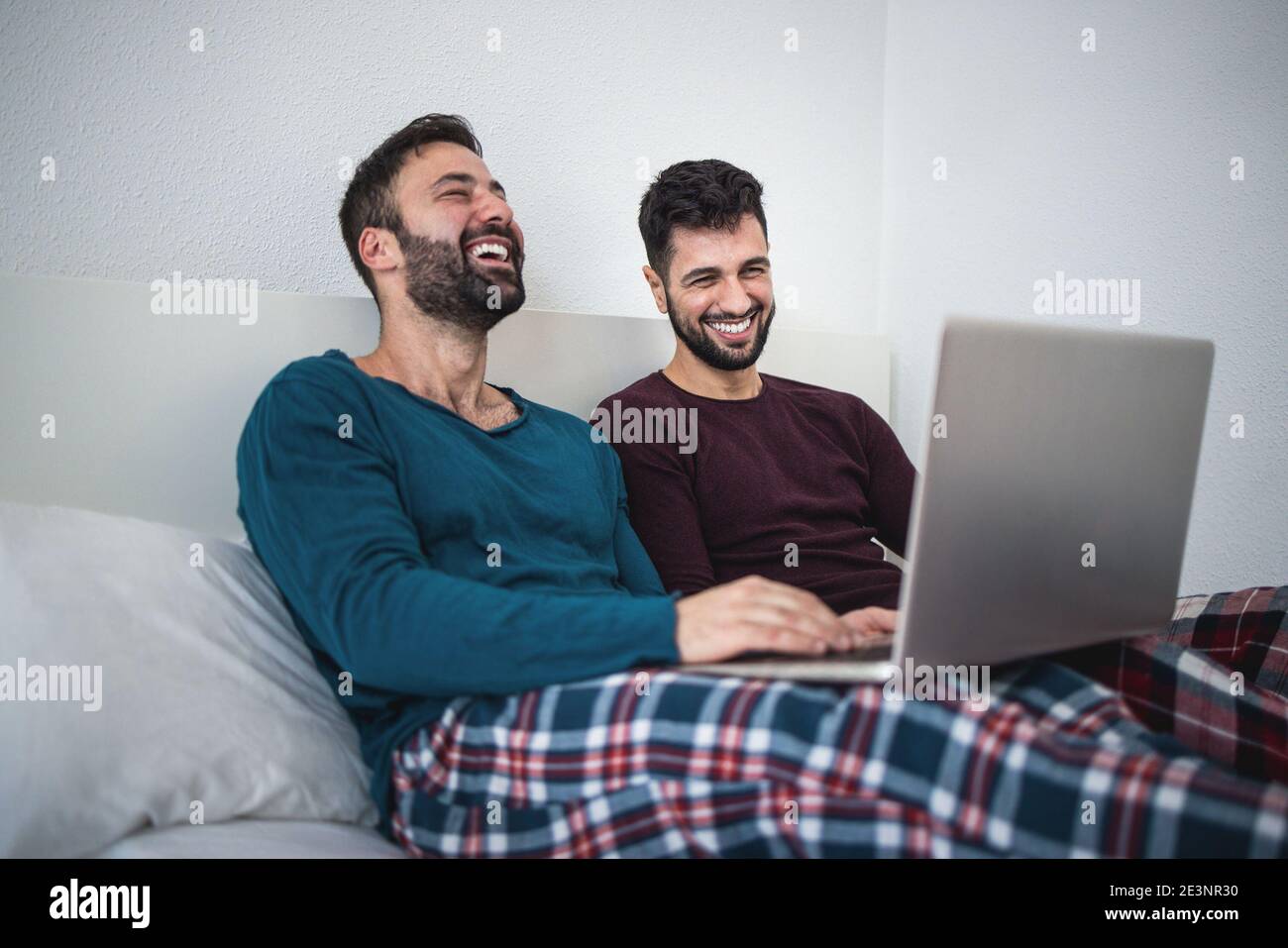 Des hommes gais heureux se coupent à l'aide d'un ordinateur portable lors de l'isolement de verrouillage - Focus sur l'homme droit Banque D'Images