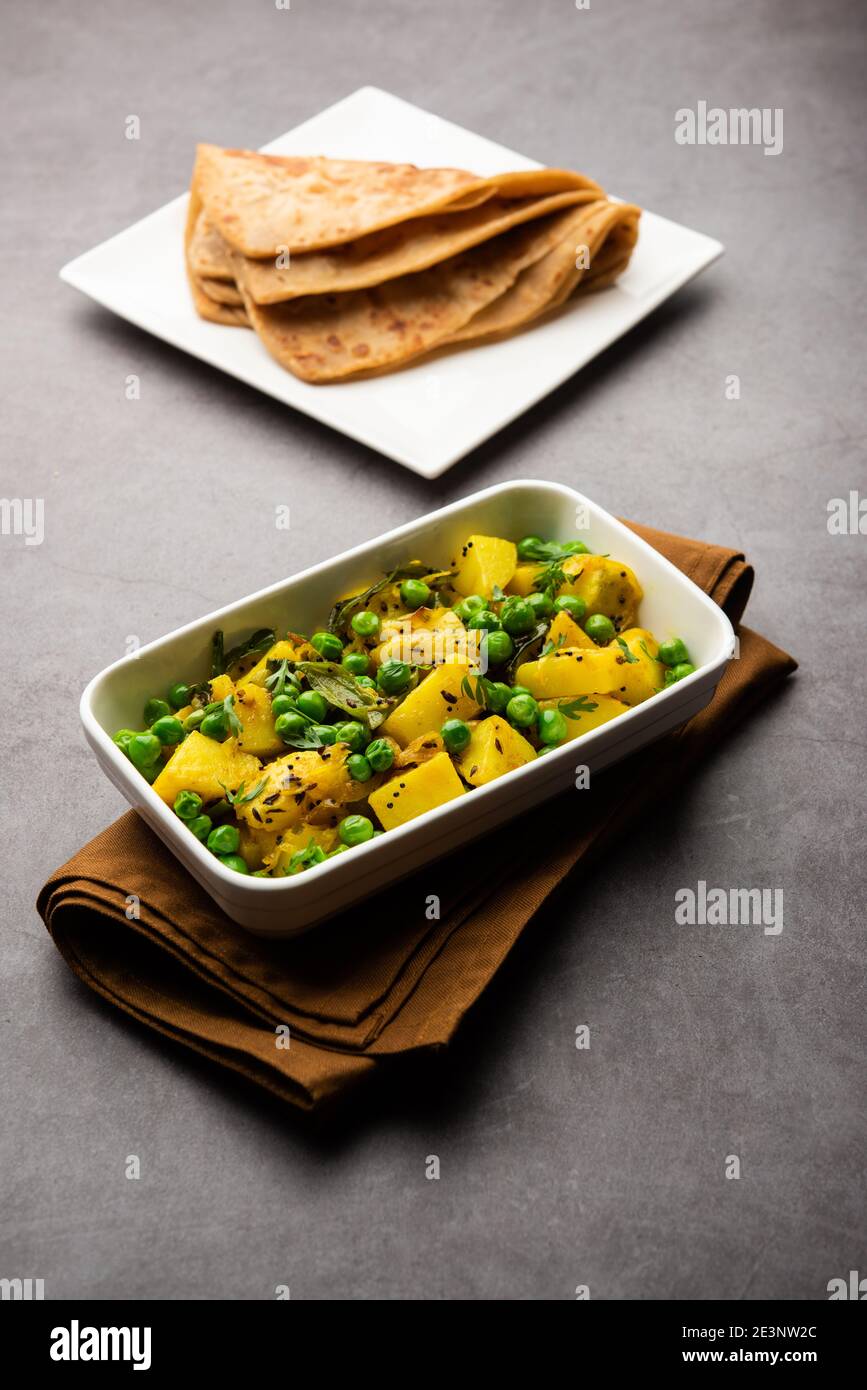 Aloo Mutter ou Matar aalu sabzi sec, pommes de terre indiennes et pois verts frits avec des épices et garni de feuilles de coriandre. Servi avec du roti ou Banque D'Images