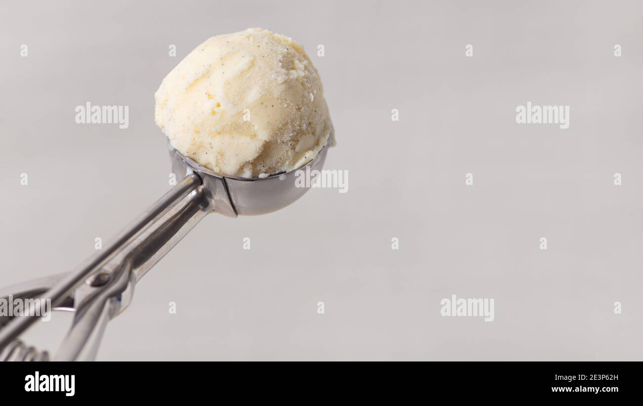 Cuillère moulée de glace à la vanille dans la glace pelle d'un glacier Banque D'Images