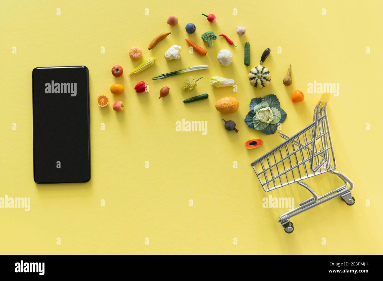 Concept d'achat en ligne - différents aliments et téléphone sur jaune arrière-plan Banque D'Images