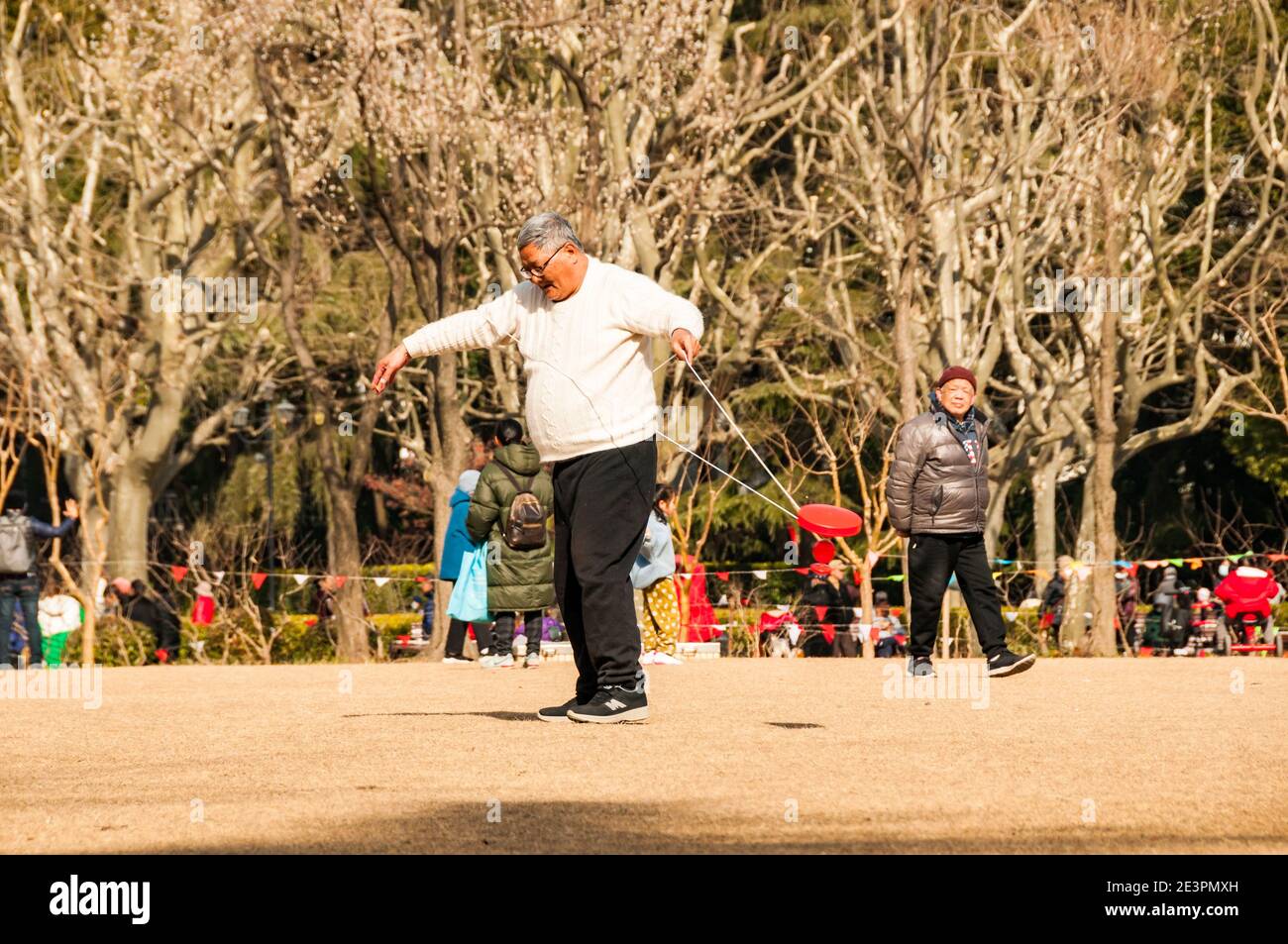 Un homme s'exerce à l'aide d'un yo-yo chinois dans le Fuxing Park de Shanghai. Banque D'Images