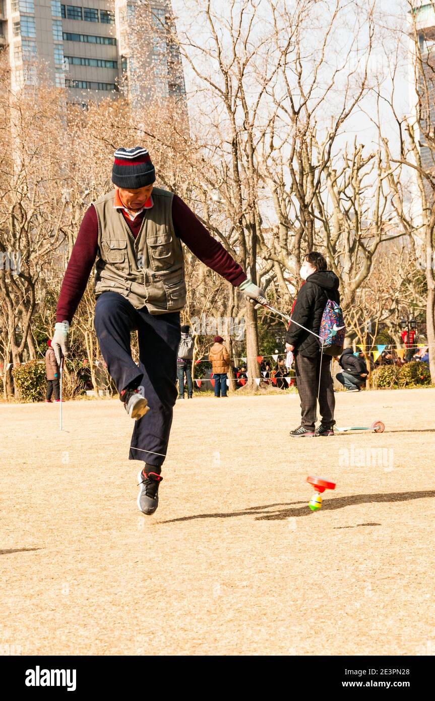 Un homme s'exerce à l'aide d'un yo-yo chinois dans le Fuxing Park de Shanghai. Banque D'Images