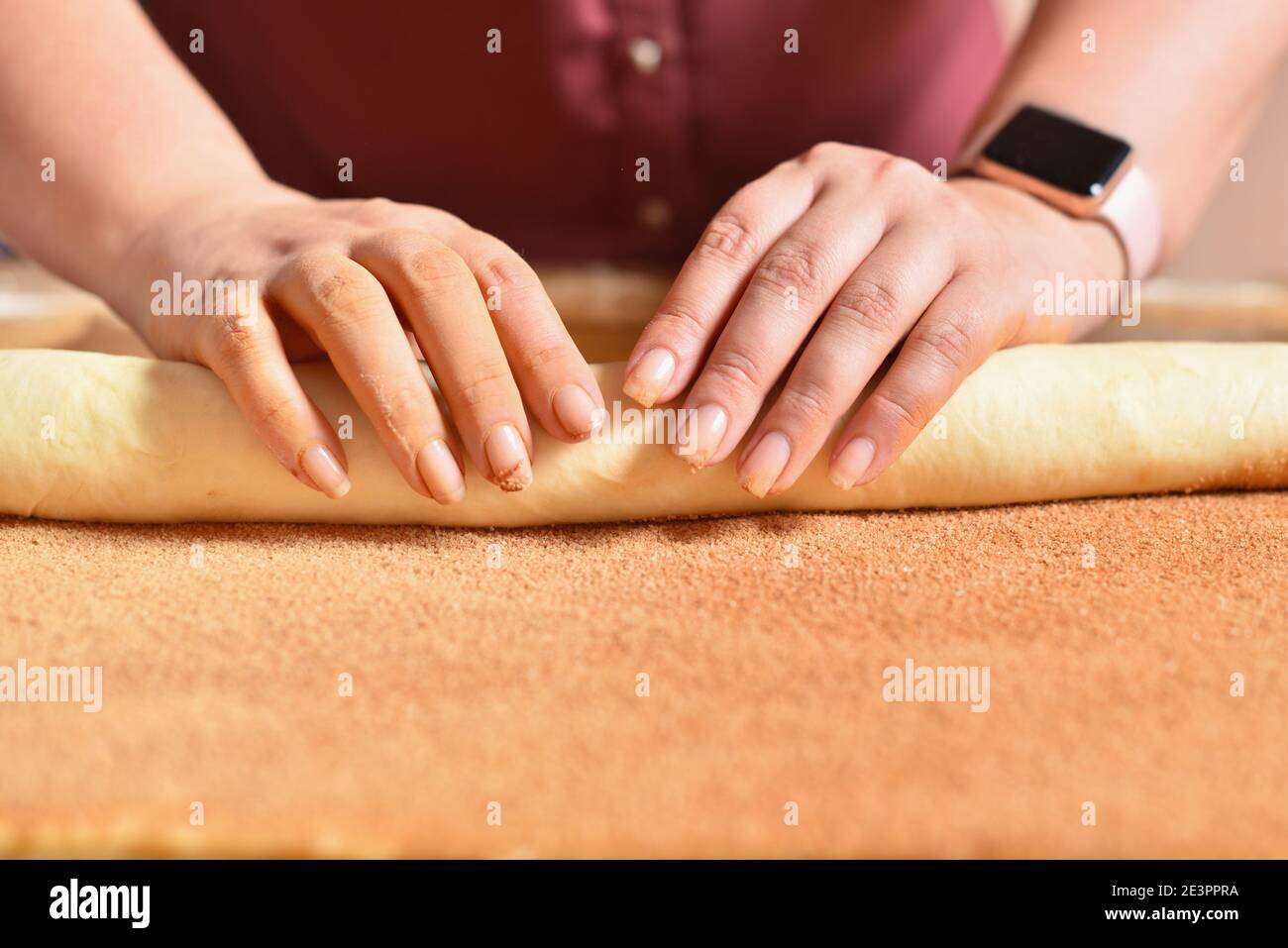 La femme de ménage fait des petits pains à la cannelle, faisant de la pâtisserie maison Banque D'Images