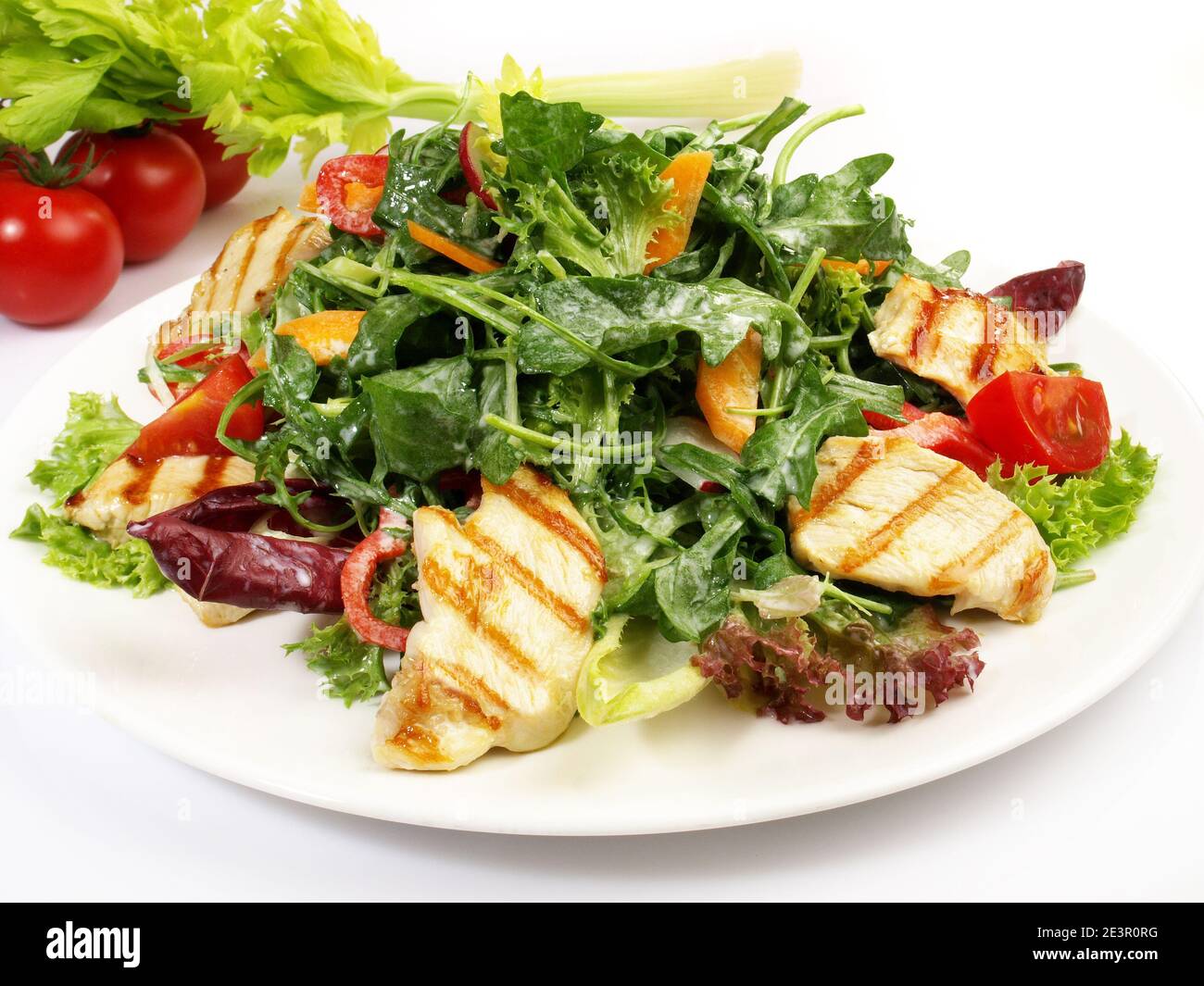 Salade mixte avec épinards et roquette et poulet grillé Isolé sur fond blanc Banque D'Images