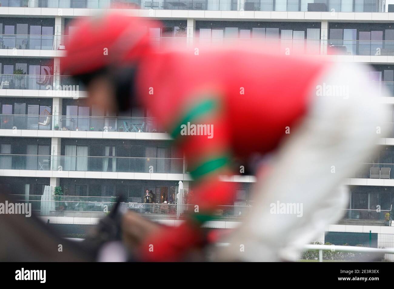 Un résident d'un appartement qui surplombe le parcours regarde l'action à l'hippodrome de Newbury. Date de la photo: Mercredi 20 janvier 2021. Banque D'Images