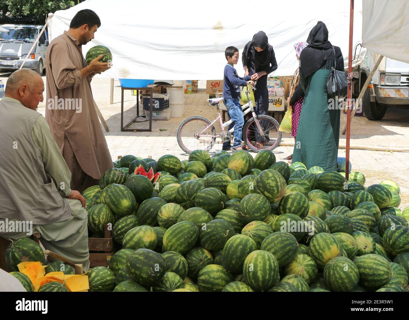 OVAKENT,HATAY,TURQUIE-JUIN 3:l'homme ouzbek choisit une pastèque mûre sur le marché agricole.juin 3,2017 à Ovakent,Hatay,Turquie. Banque D'Images