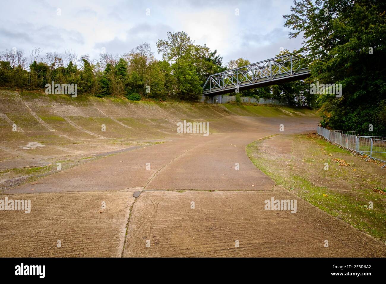 Circuit de course de Brooklands, vue sur la courbe désormais très mossy et le pont à pied de ce circuit historique anglais / lieu de courses automobiles britanniques Banque D'Images